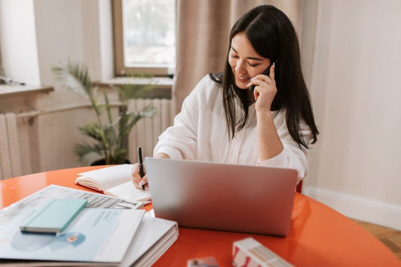 How to Actually Increase Sales in Your MLM Business 1 A woman running her small direct-sales business from home, chatting with a customer over video call surrounded by product samples