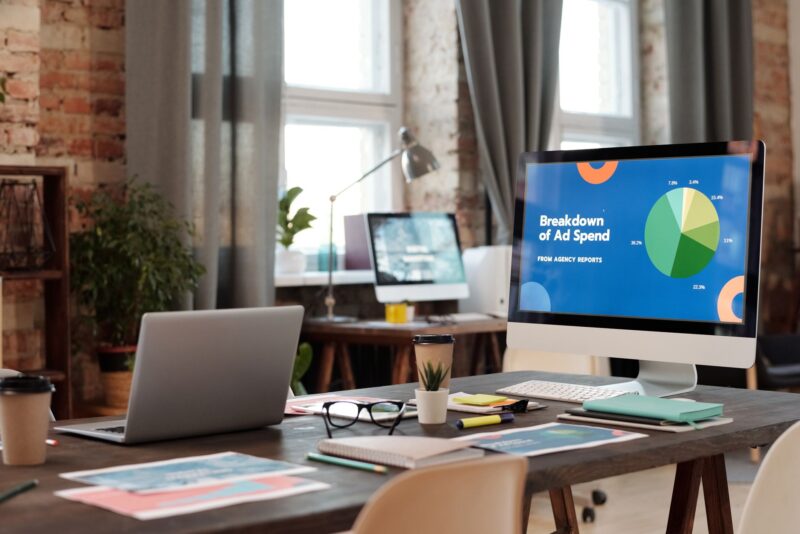 Native Ads vs Banner Traffic: When to Use Which for Better ROI 1 Two monitors on a desk comparing a native ad layout and a banner ad layout with performance charts on a tablet